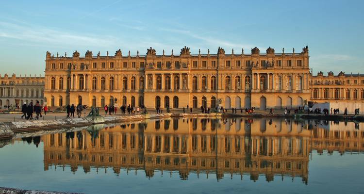 Fachada del Palacio de Versalles con una gran piscina reflectante.
