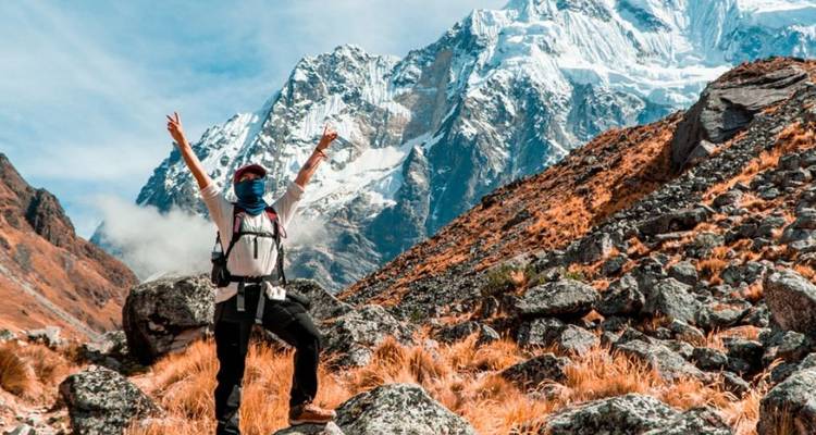 Excursionista posando frente a montañas nevadas.
