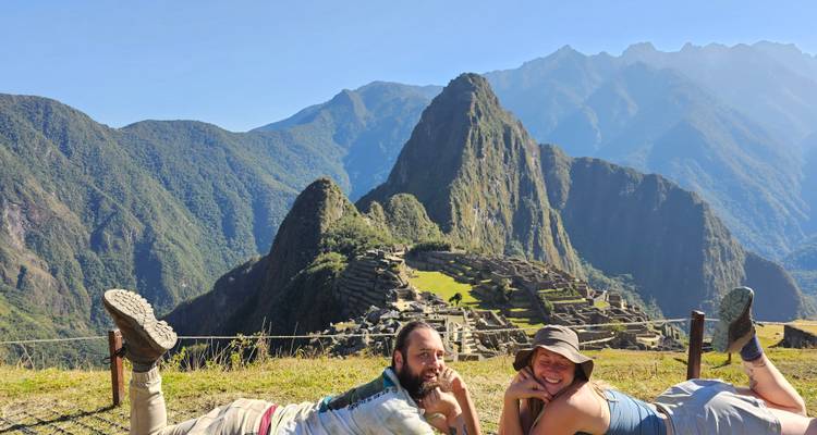 Dos personas posando juguetonamente con Machu Picchu de fondo.