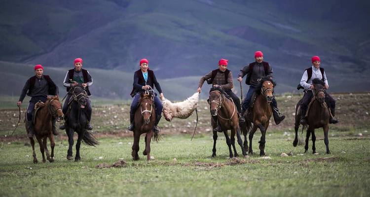 Groep ruiters die deelnemen aan een traditionele Kirgizische sport met een schapenkarkас.
