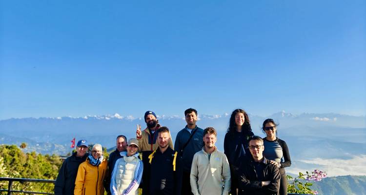 Touristen, die vor einem Bergpanorama posieren.