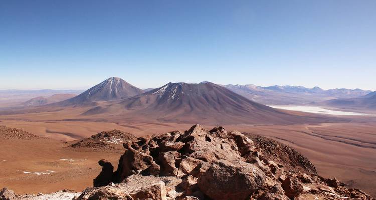 Distant view of mountainous landscape under a clear blue sky.