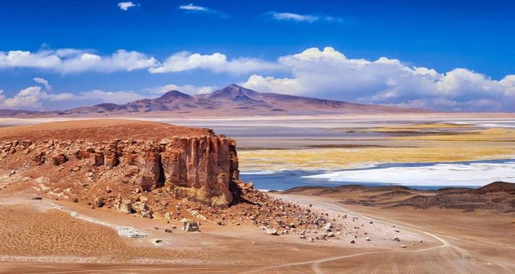 Vast desert landscape with rock formations and mountains.
