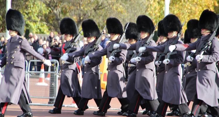 Marching soldiers in grey coats and bearskin hats during guard ceremony