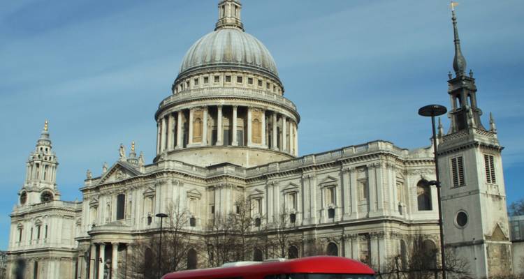 St Paul’s Cathedral dome with classic red London bus passing in foreground