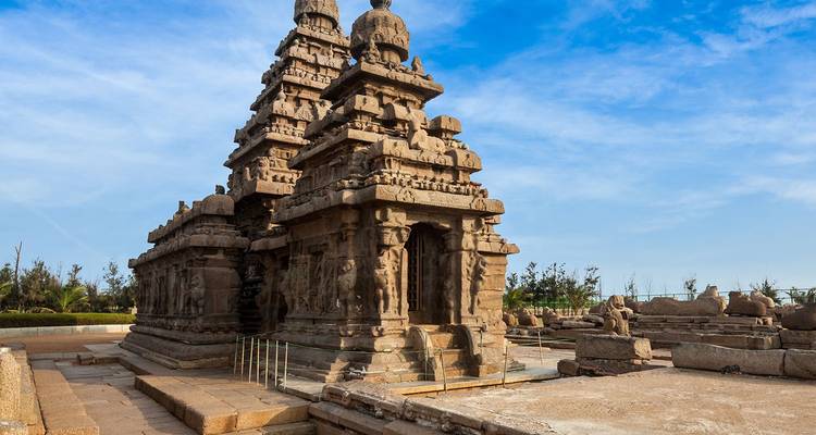 De eeuwenoude Shore Temple uit steen gehouwen staat tegen een levendige blauwe hemel in Mahabalipuram.