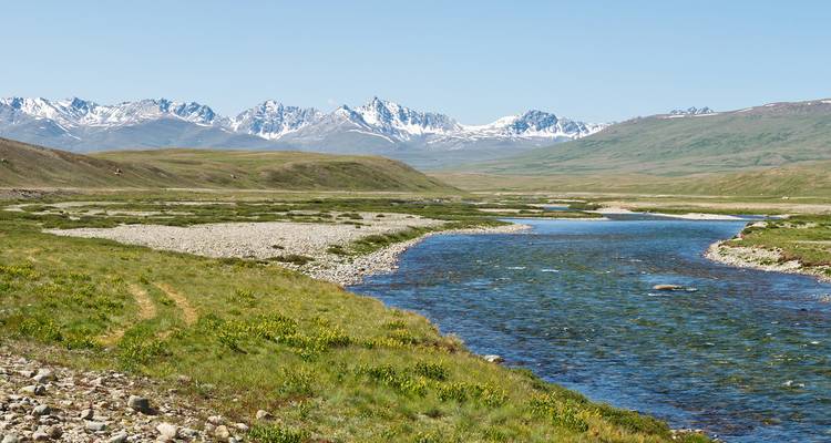 Vista amplia de un río con una cadena montañosa en el fondo.