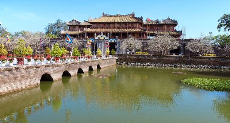 Imperial Citadel entrance with stone bridge over moat and ornamental flags