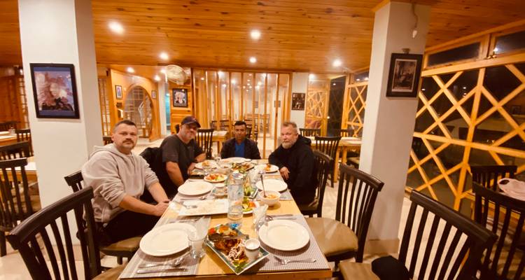 Vier Männer sitzen an einem Esstisch in einem Restaurant.