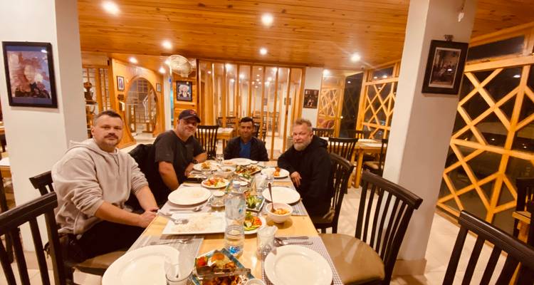 Vier Männer genießen eine Mahlzeit in einem Restaurant.