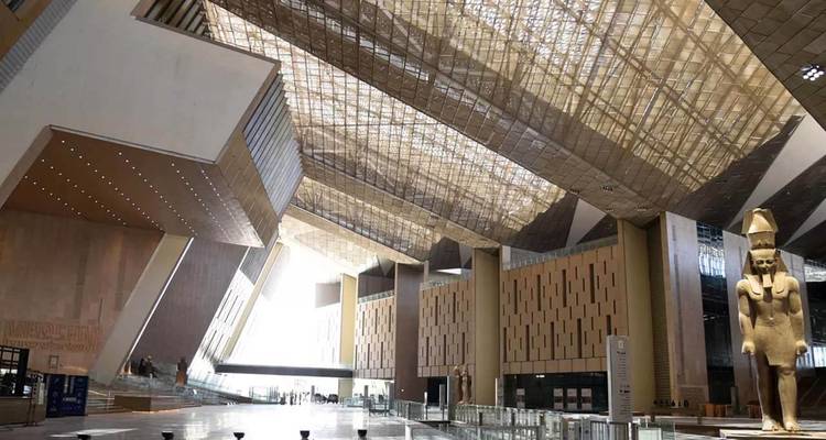 Grand hall intérieur d'un musée moderne avec statue égyptienne.