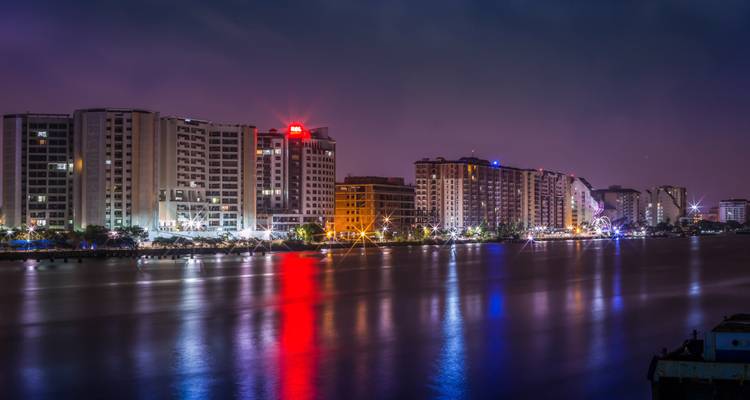 Stadshorizon 's nachts met reflecties in het water.