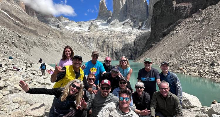 Un gran grupo celebra en la base de las torres de granito de Torres del Paine junto a un lago lechoso