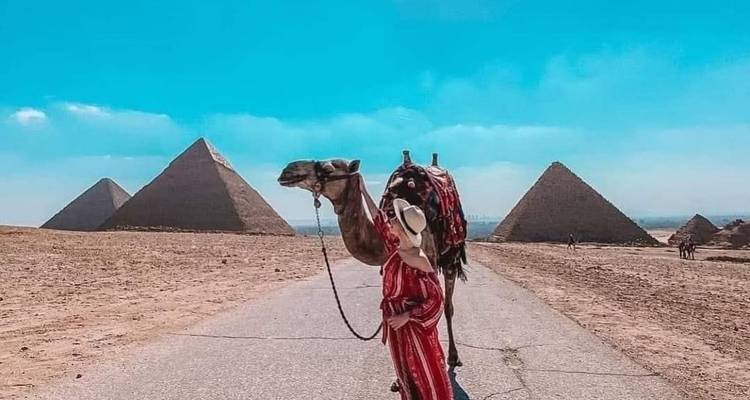 Toerist met een kameel en piramides op de achtergrond in Egypte.