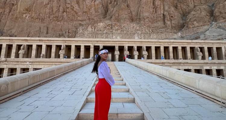 Vrouw poseert voor de Hatsjepsoet-tempel in Luxor, Egypte.