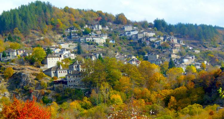 Colorful autumn hillside dotted with stone houses of a mountain village.