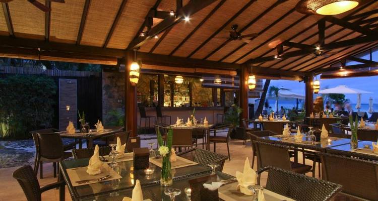 Tropisches Restaurant-Ambiente in Strandnähe mit stimmungsvoller Beleuchtung.