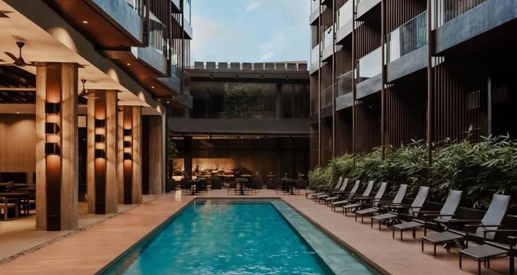 Modernes Hotel mit einem schmalen Swimmingpool und stilvoller Sitzecke.
