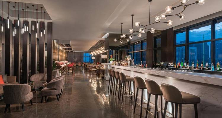 Eleganter Barbereich mit moderner Beleuchtung und Stadtblick.