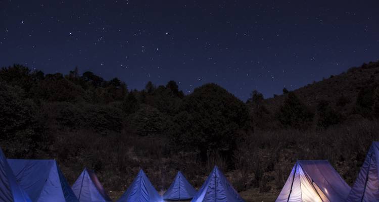 Tents under a starry night sky.