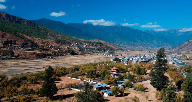 Aerial view of a valley with mountains in the background.