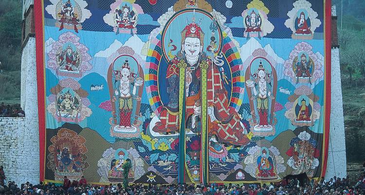 Large religious tapestry displayed on a building with a crowd.