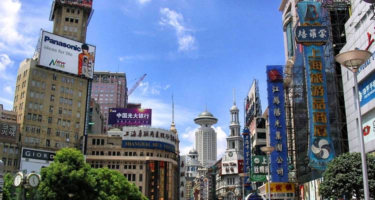 Rue commerçante animée à Shanghai avec signalétique.