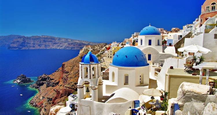 Edificios blancos con cúpulas azules que dan al mar.