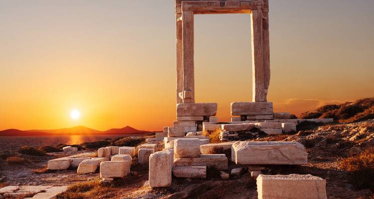 Antiguas ruinas de un templo con una impresionante puesta de sol como telón de fondo.