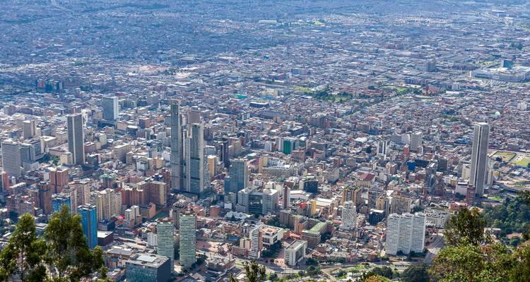 Panorama aéreo expansivo del denso paisaje urbano de Bogotá extendiéndose hasta el horizonte.