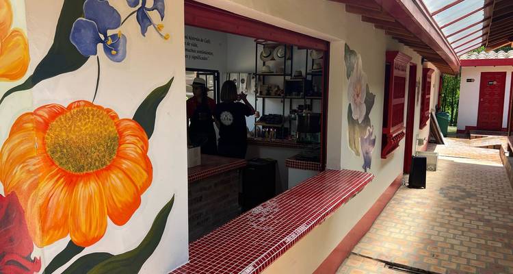 Mostrador exterior de una cafetería decorado con flores pintadas grandes y ventanas abiertas.