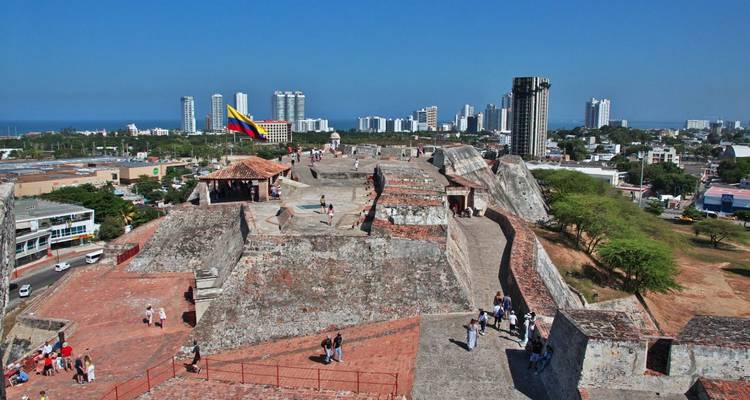 View along the ramparts of Castillo San Felipe with visitors exploring under a clear blue sky.