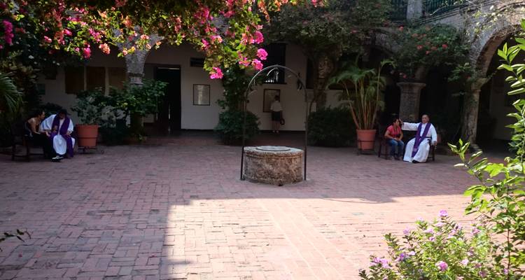 Sunlit courtyard with a central well, blooming bougainvillea and quiet seating areas.