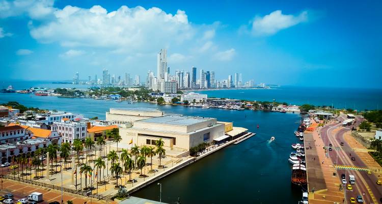 Aerial panorama of Cartagena’s waterfront, modern skyline and Caribbean blue sea under bright skies.