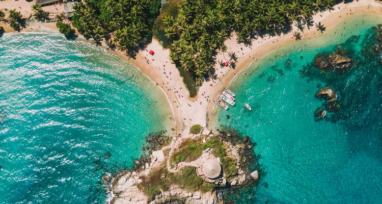Vue aérienne de haut en bas de deux criques, eau turquoise, palmeraie et plages de sable fin à Tayrona.