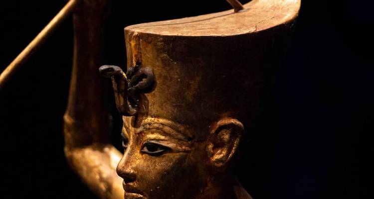 Close-up van een oud-Egyptisch standbeeld dat een staf vasthoudt.