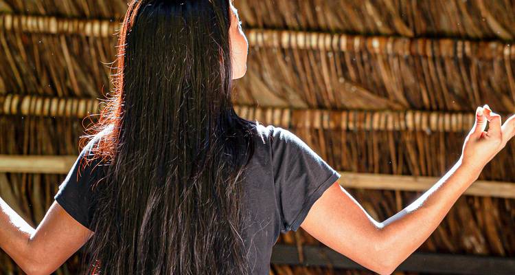 Personne en méditation dans une structure rustique en bois.