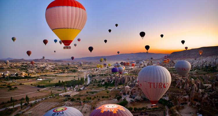 Montgolfières au-dessus d'un paysage de Cappadoce au crépuscule.