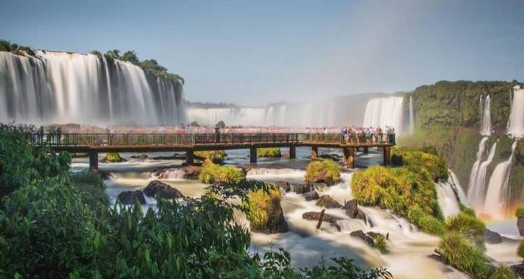 Cataratas del Iguazú con puente y turistas observando las cascadas.