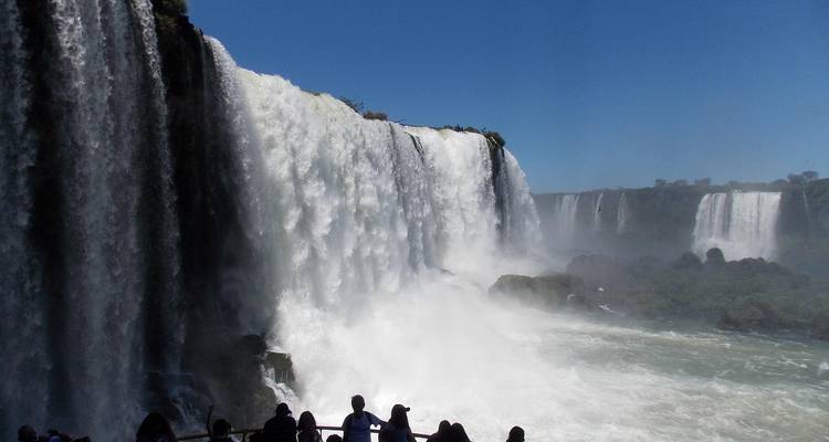 Vista cercana de las Cataratas del Iguazú con neblina y turistas observando.