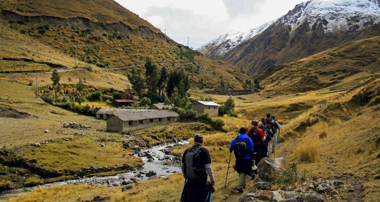 Grupo de senderismo caminando por un valle montañoso.