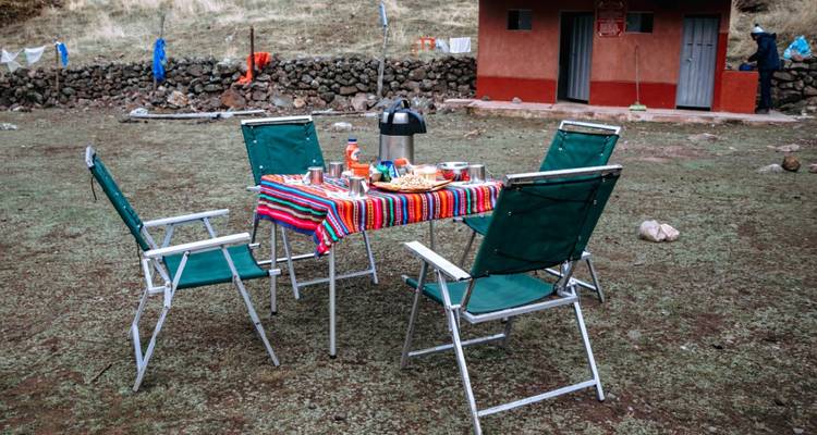 Mesa al aire libre con sillas y comida.