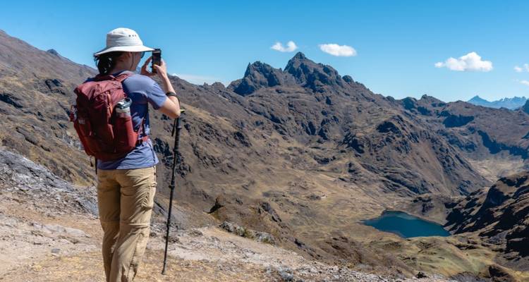 Excursionista con cámara tomando una vista panorámica de las montañas.