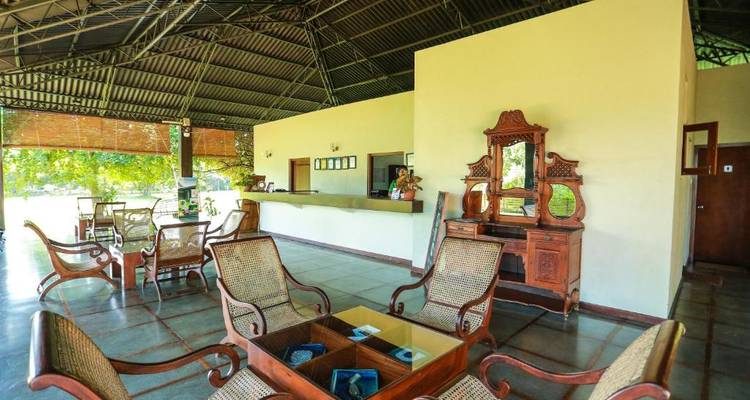 Lobbybereich mit traditionellen Holzmöbeln und offenem Dach.