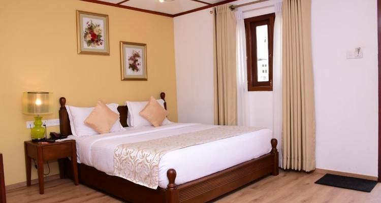 Gemütliches Schlafzimmer mit Dekokissen und gerahmter Kunst.