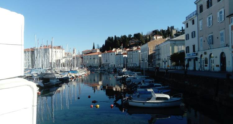 Port avec des bateaux amarrés près de bâtiments historiques à Koper, Slovénie.