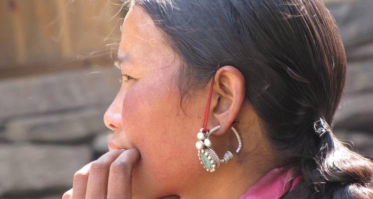 Close-up of a woman's profile with traditional jewelry, looking away from the camera.