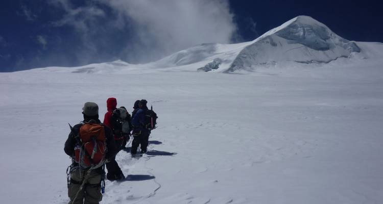 Group of climbers trekking up a snowy slope.