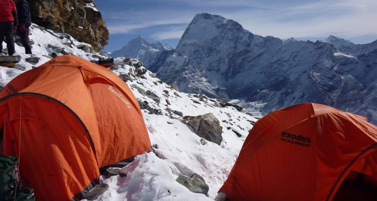 Tents set up on a snowy mountain with scenic views.