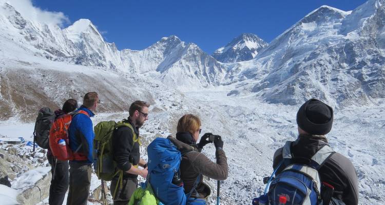 Randonneurs observant les vastes étendues de montagnes enneigées.
